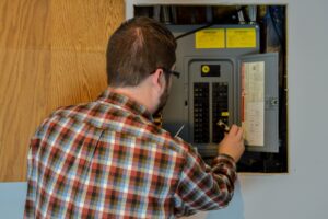 Man repairing and upgrading electrical panel for home electrical upgrade.