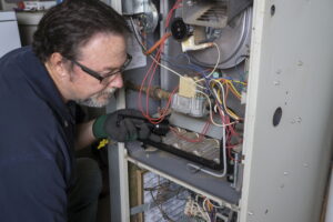 Technician working on the electrical panel of a heater.