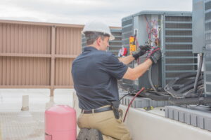 HVAC-technician-working-on-cabinet