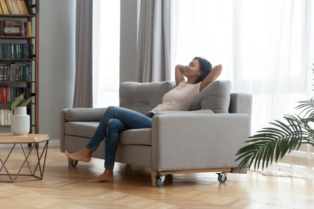  Serene woman leaned on couch resting at home